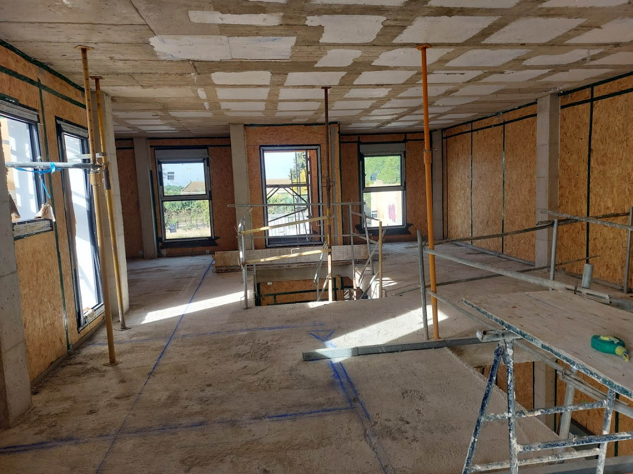 Técnico especializado instalando la membrana de hermeticidad continua para certificación Passivhaus con sellado multicapa
