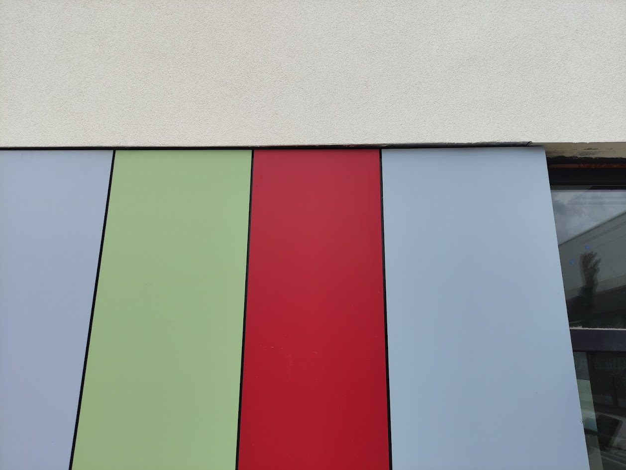 Detalle de paneles HPL Trespa® con textura satinada y colores vibrantes instalados en fachada ventilada