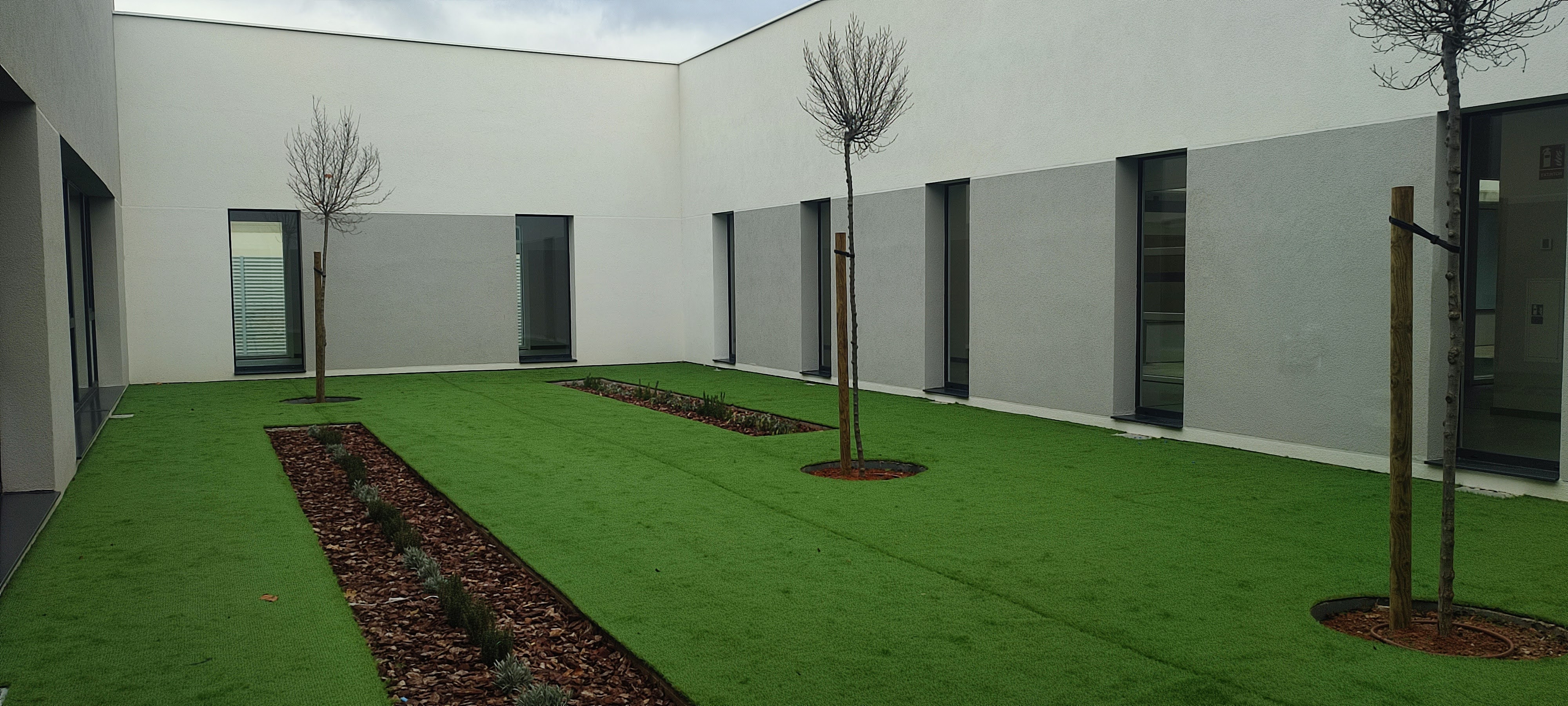 Vista completa del centro educativo CEIP34 con fachada ventilada terminada integrándose en el entorno urbano de Albacete
